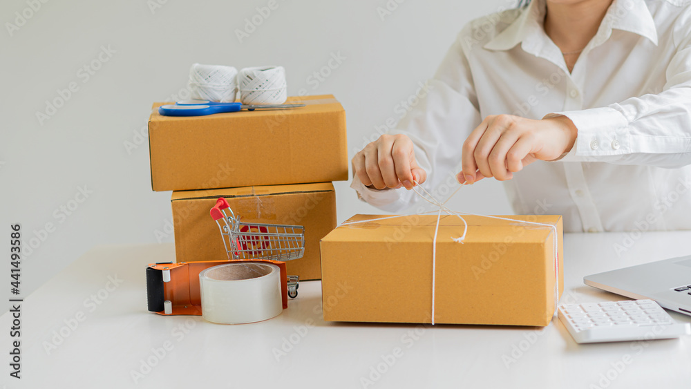 Start small business, business woman, successful SME entrepreneur. Work-at-home woman with laptop taking orders from customers with online parcel delivery. SME delivery concept and packaging Start small business, business woman, successful SME entrepreneur. Work-at-home woman with laptop taking orders from customers with online parcel delivery. SME delivery concept and packaging