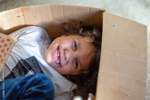 Little boy playing in a cardboard box photo