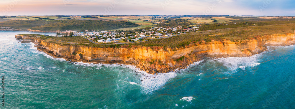 Aerial panorama of a coastal town on sea cliffs above a rugged coastline