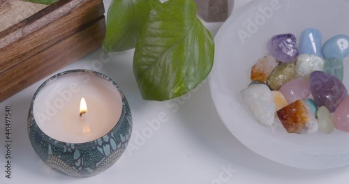 Closeup of healing crystals in a selenite bowl and a candle photo