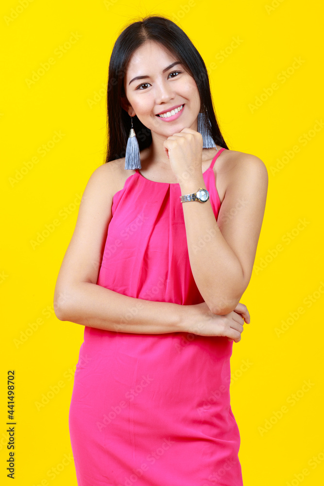 Asian beautiful cheerful adult woman with long black hair wearing pink dress pose in thinking gesture isolated on yellow background and copy space. Asian beautiful cheerful adult woman with long black hair wearing pink dress pose in thinking gesture isolated on yellow background and copy space.