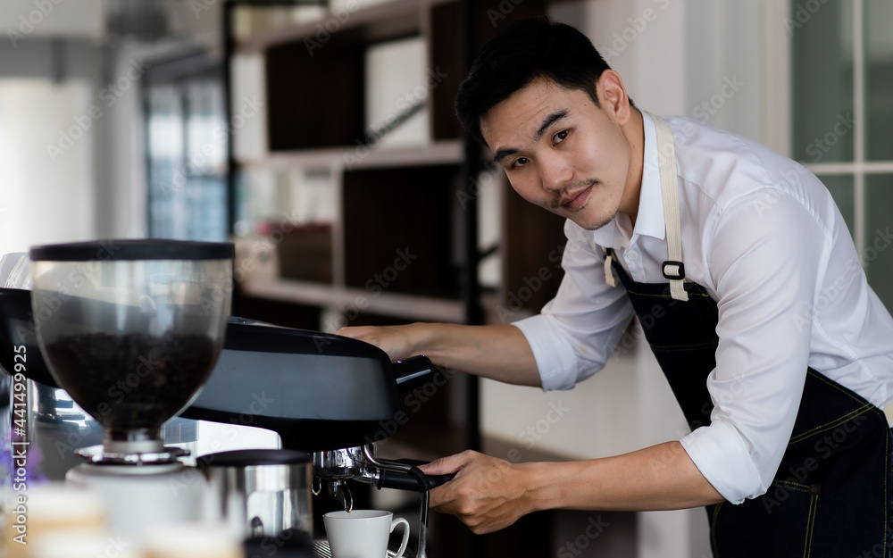 Image of Silhouette. Asian young man using a coffee machine. Rinse the coffee with warm water. Asia man preparing for pressing ground coffee for brewing espresso or americano in a cafe.