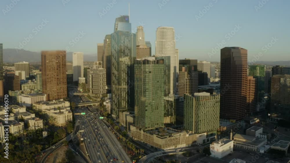 Aerial Panning Traffic And The Soaring Skyscrapers And Downtown Skyline With Clear Blue Skies And Bright Sunlight Reflecting Off The Building Windows - Los Angeles, California Aerial Panning Traffic And The Soaring Skyscrapers And Downtown Skyline With Clear Blue Skies And Bright Sunlight Reflecting Off The Building Windows - Los Angeles, California
