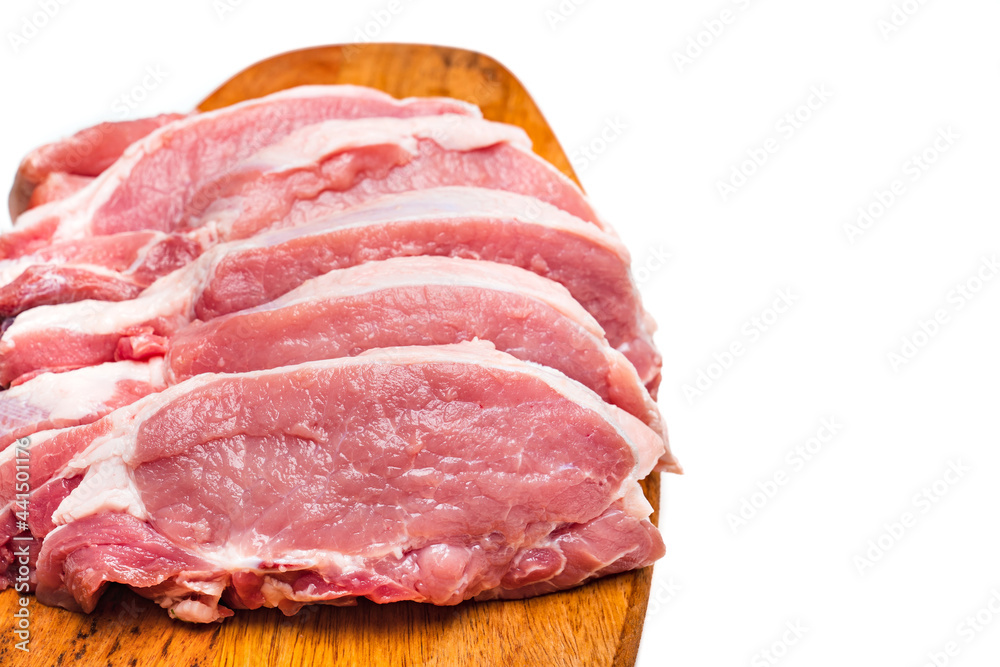chopped into pieces raw pork on a wooden cutting board on a white background.