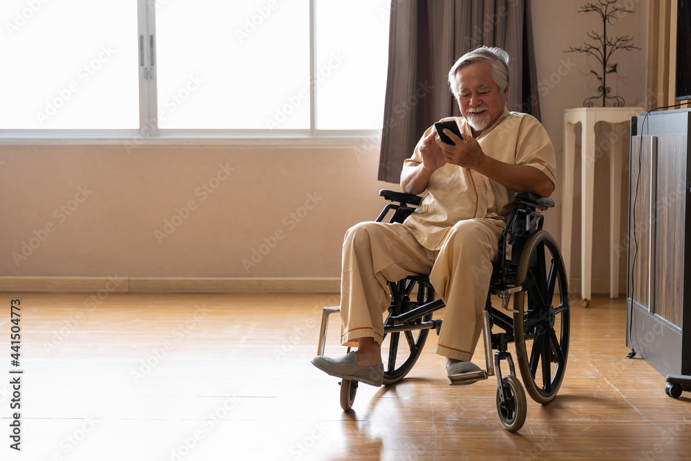 Asian elderly man sitting on wheelchair and using smart phone in patient  room at the hospital. Patient man on wheelchair in room at hospital Stock  Photo | Adobe Stock