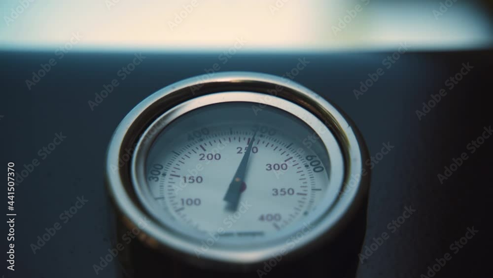 Camera tilts down to a barbecue thermometer. Camera tilts down to a barbecue thermometer.