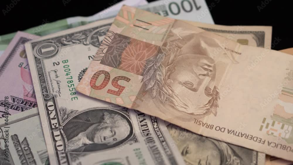 Dropping American Dollars and Brazilian Reals Banknotes on Euros. Exchange Rate and Economy Loss Concept, Close Up Full Frame Dropping American Dollars and Brazilian Reals Banknotes on Euros. Exchange Rate and Economy Loss Concept, Close Up Full Frame