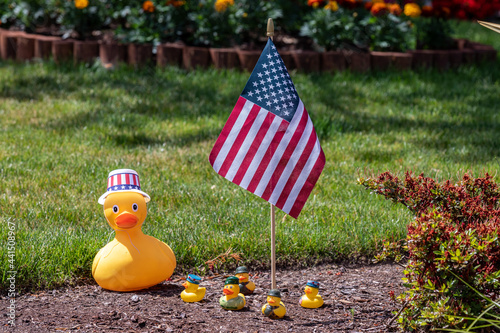 Hillsboro, Oregon  USA - 05 May 2021: Large yellow rubber duck in Uncles Sam hat next to the American flag with a group of small rubber duck dressed like soldiers. Memorial day theme