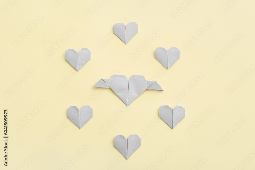 Origami hearts on color background. Concept of uniqueness