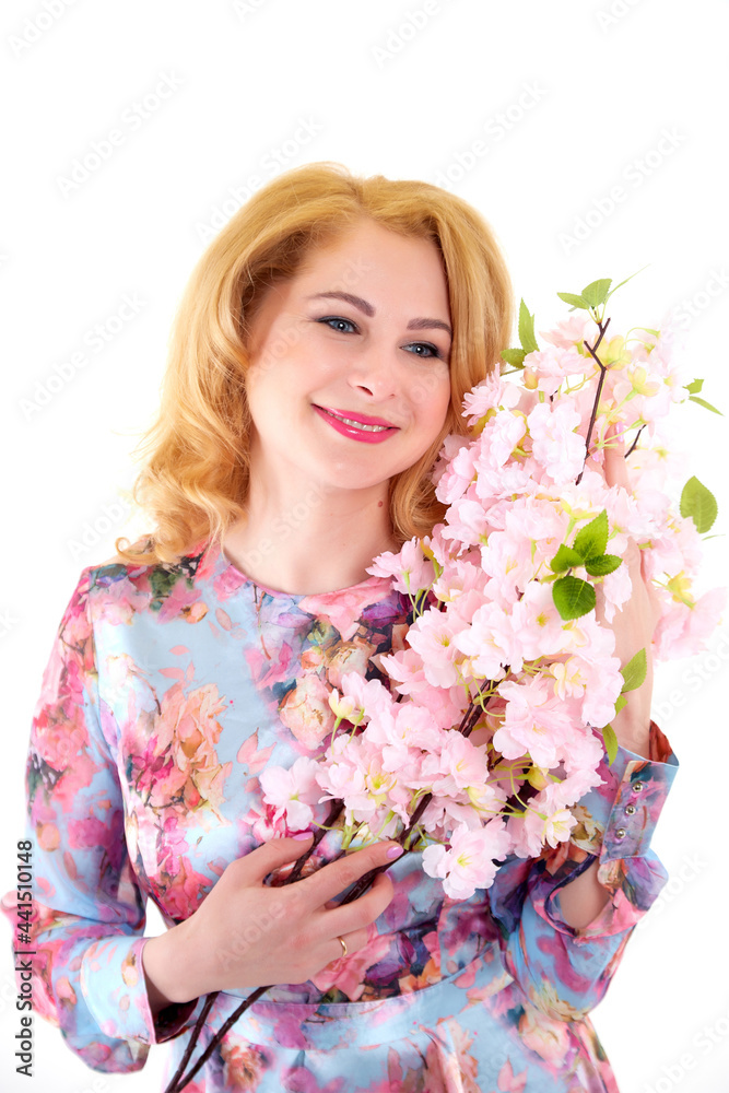 Happy beautiful woman with long blond curly hair posing with flowers in studio on white background