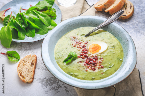 Creamy sorrel soup with egg and bacon bits photo