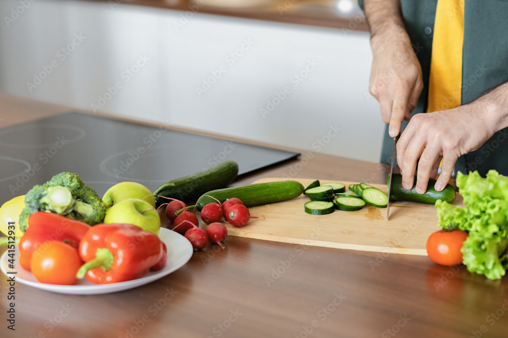 Healthy lifestyle background, male hands cut fresh vegetables for cooking delicious and healthy food, in home kitchen