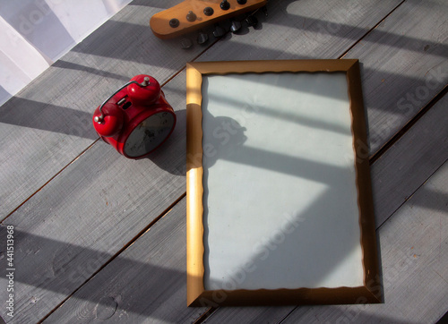A frame for your lettering, a guitar neck on a gray wooden table, a sunny morning. The concept of congratulations, wishes, good morning.	