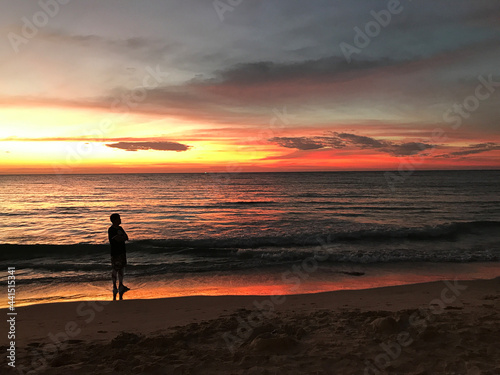 A man standing alone watching the scenery after the sunset at Klong Chaow beach on Ko Kut in Trat, Thailand.