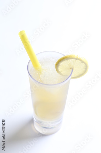 ice cold chilled fresh sour lemon fruit honey drink in glass and yellow straw beverage menu in white background