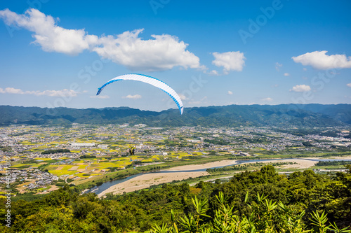 青空に向かって飛び立つパラグライダー。 紀の川市寺山スカイスポーツにて