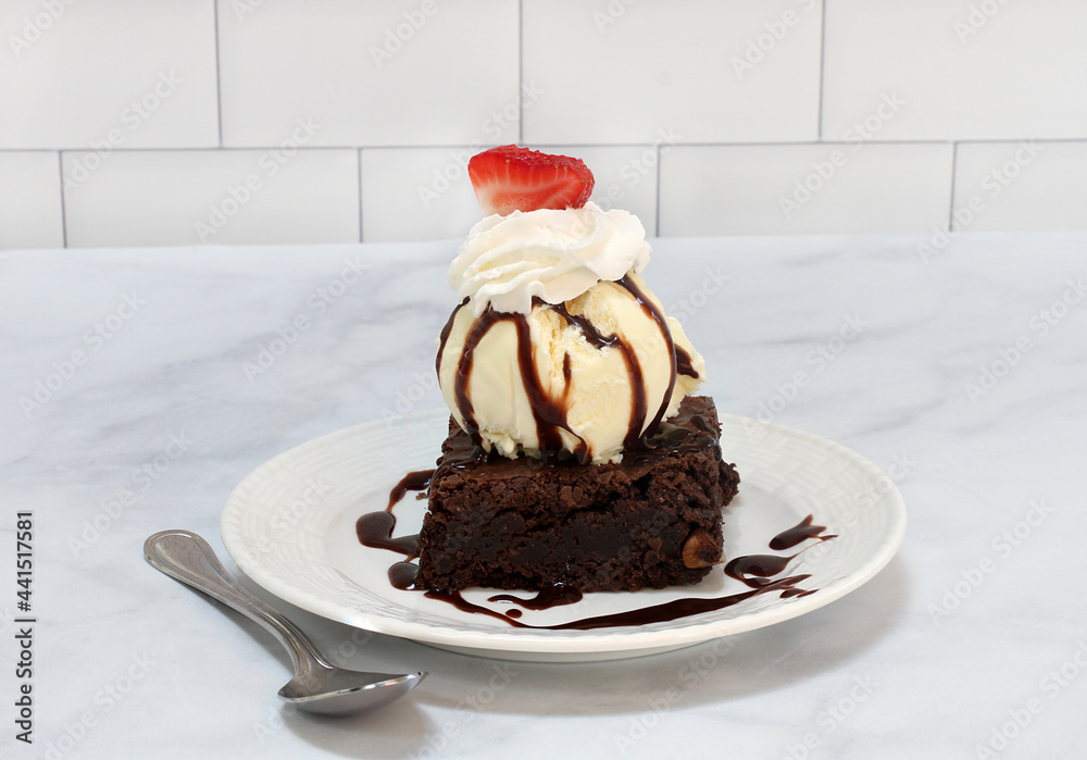 Brownie Ice Cream Sundae topped with a strawberry slice Brownie Ice Cream Sundae topped with a strawberry slice