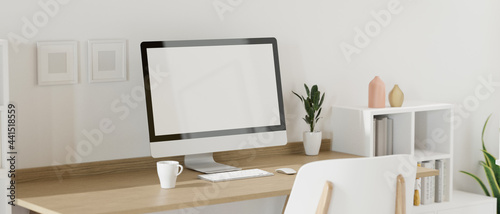 Computer device with mock-up screen on the table in home working space with decorations and bookshelf, 3D rendering © bongkarn