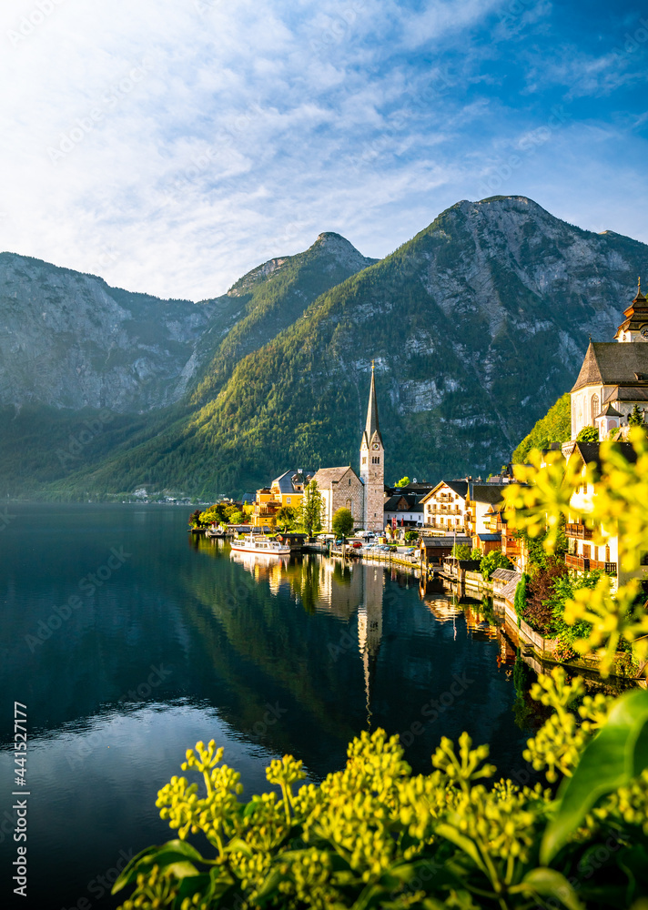 Fototapeta premium Panorama Sonnenaufgang am See in Hallstatt Österreich Schiff an Anlegestelle Berg Kirche Alpen Dorf Landschaft Natur Hallstätter See Sunrise Lake in Austria Ship Mountain Alps Church Landscape Nature 