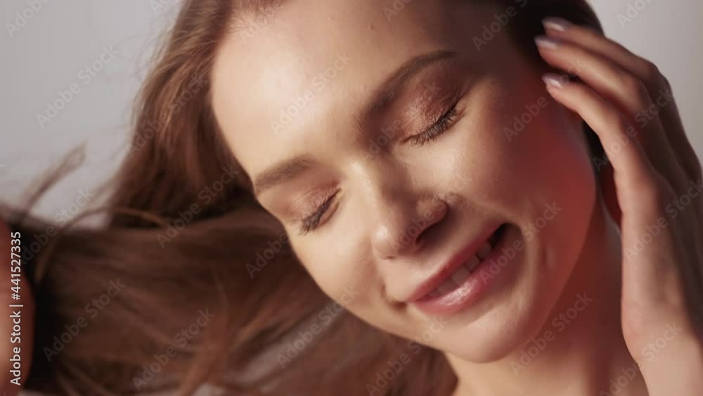 Skin hair health. Beauty cosmetics. Wellness freshness. Happy smiling brunette woman with nude makeup perfect radiant face bare shoulders posing isolated on beige. Skin hair health. Beauty cosmetics. Wellness freshness. Happy smiling brunette woman with nude makeup perfect radiant face bare shoulders posing isolated on beige.