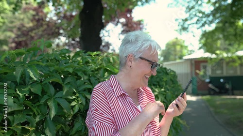 Portrait of senior woman in the backyard having a video call.