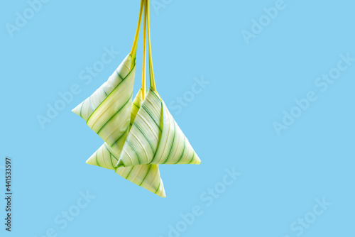 Glutinous rice wrapped with leaves on blue background. Also known as Ketupat Palas. Served during eid festival by Muslim.