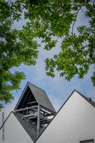 Clock tower detail with angular wood construction and bright white concrete wall