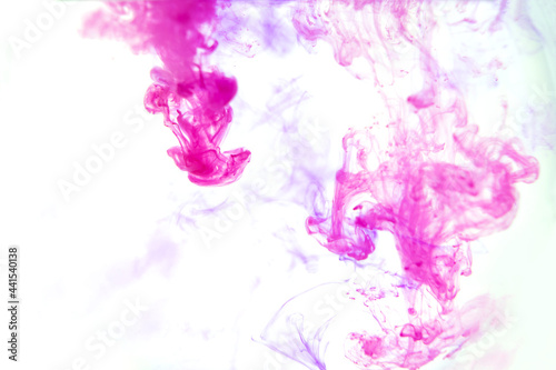 Beautiful ink mix macro. Pink, purple, violet, white colors watercolor pouring. Paint movement macro. Fluid art painting. Moving flowing stream of liquid paint. Decorative abstract background.