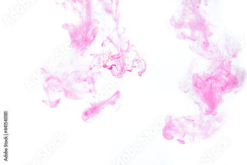 Bright pink purple acrylic paint swirling in water. Ink moving in liquid creating abstract clouds. Traces of colorful dissolving in water, changing shape. Abstract decorative creative background.