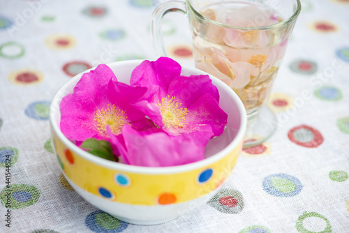 Rugosa rose flowers in the bowl and herbal rose tea.