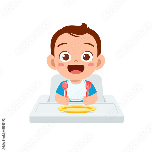 cute little baby boy eat porridge in bowl with spoon