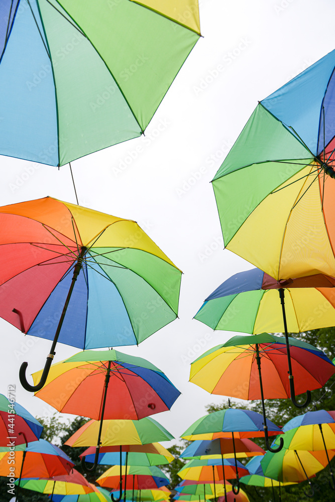 A lot of umbrellas hanged in a park. Beautiful view with a lot of color. Vivid photo.