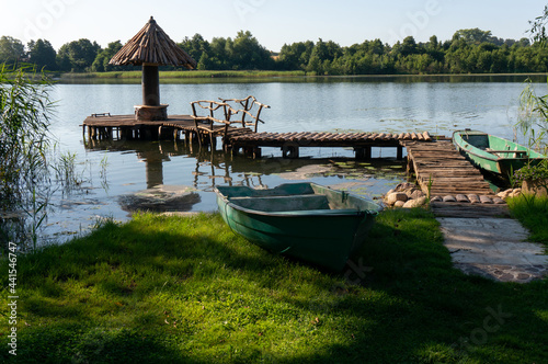 Lake Wegorzyno. Wooden umbrella, wooden pathway, plastic boats. Wegorzyno, Poland.