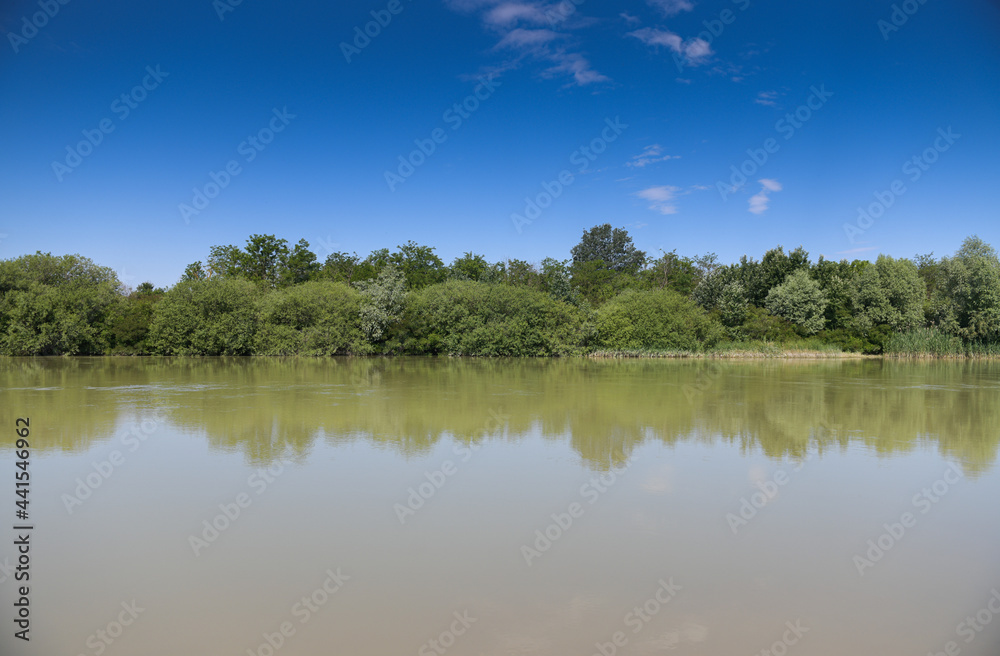 Arges river next to Bucharest in a sunny day with blue sky.