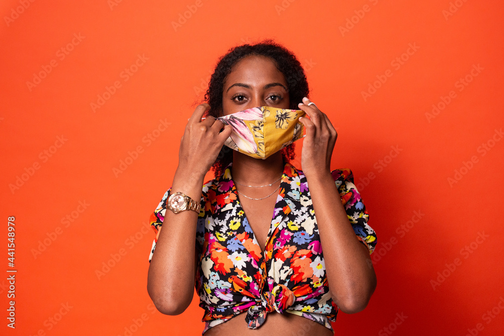 Stylish black woman putting on face mask Stock Photo Adobe Stock