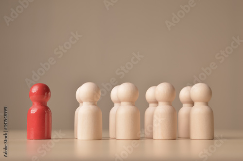 Red wooden doll figure standing in front of the group