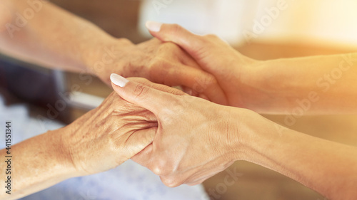 Seniors holding hands for comfort and concern
