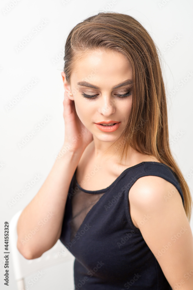 Beautiful young caucasian woman with natural makeup smiling and looking down standing on white background Beautiful young caucasian woman with natural makeup smiling and looking down standing on white background