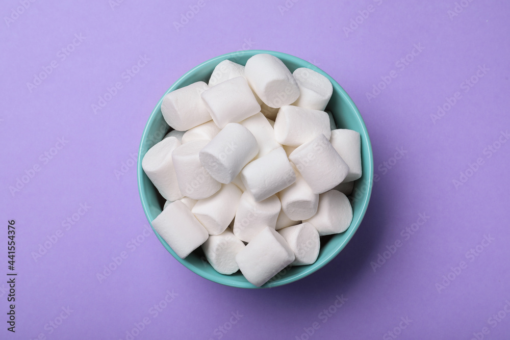 Delicious puffy marshmallows on lilac background, top view Delicious puffy marshmallows on lilac background, top view