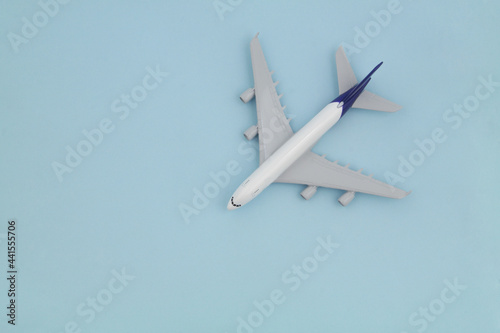 Airplane model on blue background., top view. Travel and transportation concept. Space for text.
