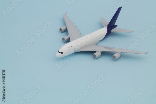 Airplane model on blue background. Travel and transportation concept.