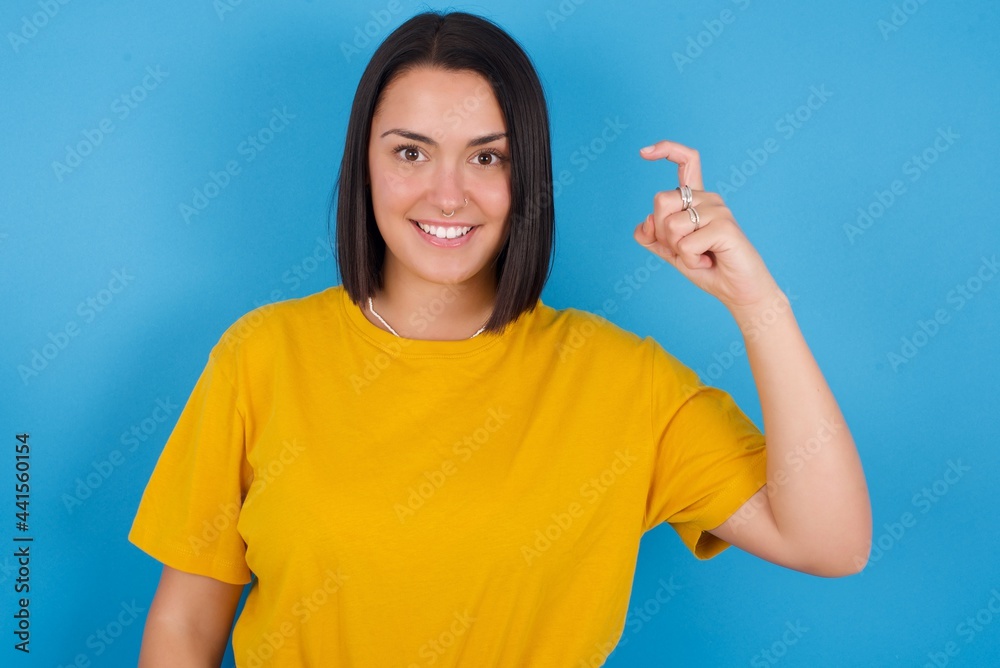 young beautiful brunette girl with short hair standing against blue background pointing up with fingers number nine in Chinese sign language Jiu young beautiful brunette girl with short hair standing against blue background pointing up with fingers number nine in Chinese sign language Jiu