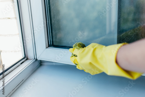 Εκτύπωση καμβά Cleaning service with gloves washes the window frame with a rag in the summer