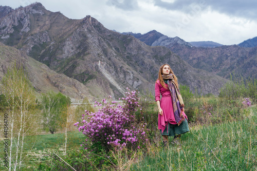 Beautiful woman wearing boho style dress standing in mountains