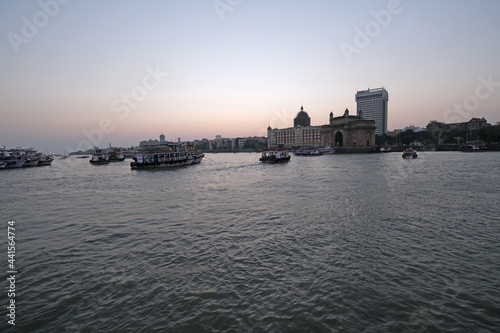 Taj Mahal hotel, Gateway of India and tourist boats in water of Arabian Sea on sunset in Mumbai, India © zatletic
