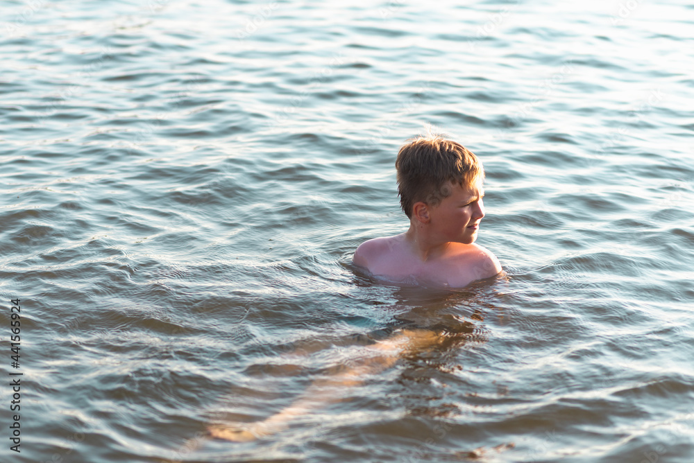 Happy smiling boy having fun swimming in the water.Cute boy swimming in water. Summer vacation. Happy smiling boy having fun swimming in the water.Cute boy swimming in water. Summer vacation.