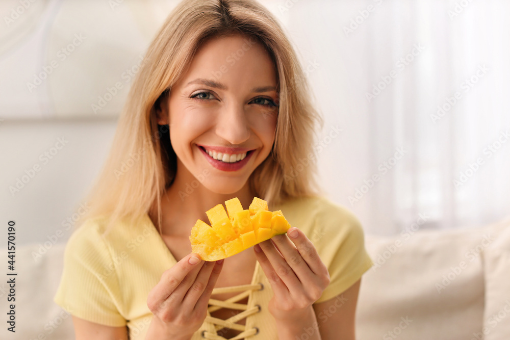 Young woman with fresh mango at home. Exotic fruit Young woman with fresh mango at home. Exotic fruit