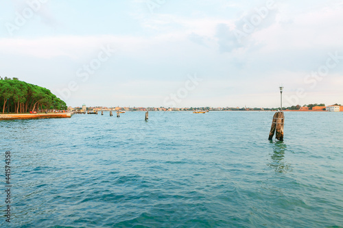 Venice water canal with old wooden berth . Water surface of lagoon in Venezia