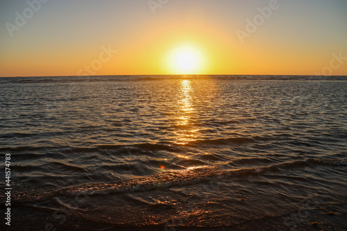 sun sinks into the sea on the beach of Katwijk with colorful sky