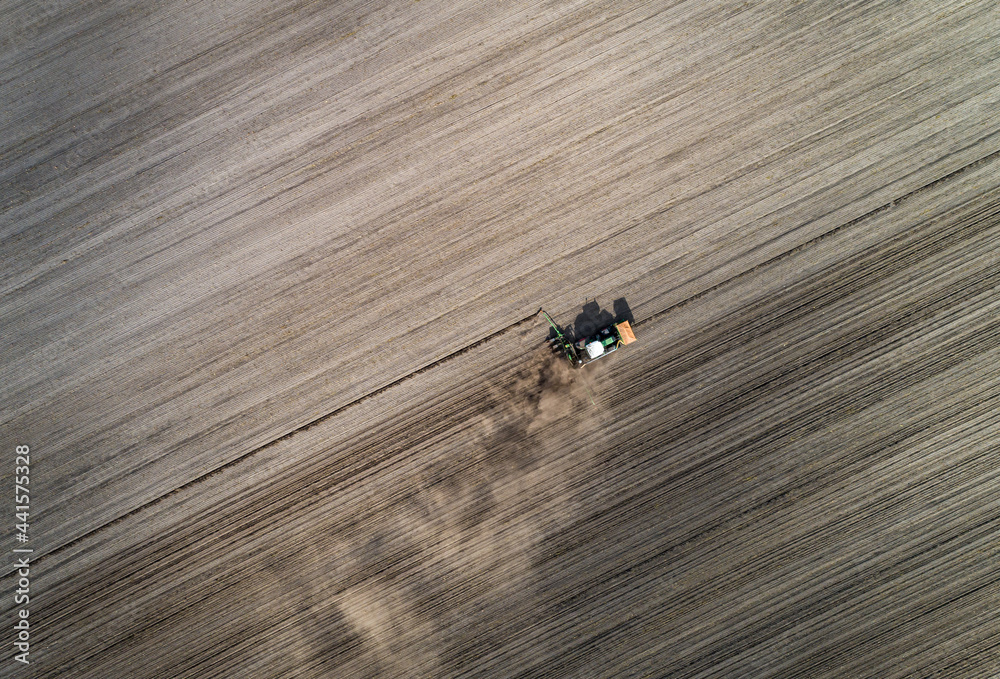 Luftaufnahme eines Schleppers mit Maislegegerät im Einsatz. Ende April bis Anfang Mai wird der Mais gelegt. 